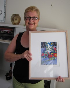 Anthea showing us her Tangerine Meg painting in her light, colorful living room.