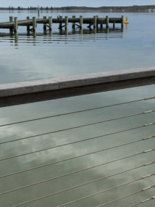 view from wharf to jetty, across rippled pale blue water