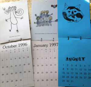 3 calendars open to display the layout and children's artwork on the pages